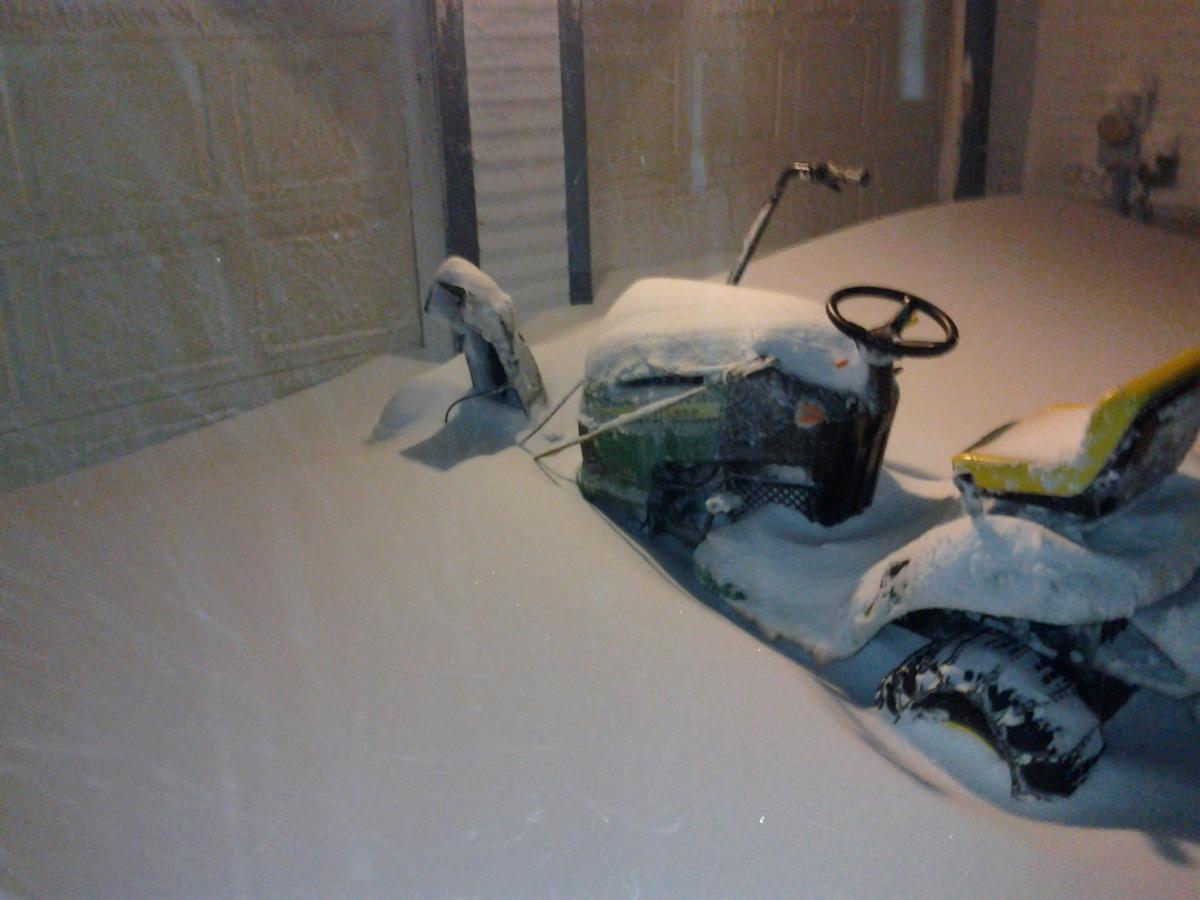 Lawn mower with a snowblower on the front. It was sitting outside for a couple hours and got buried. You can only see the chute in this picture becaus